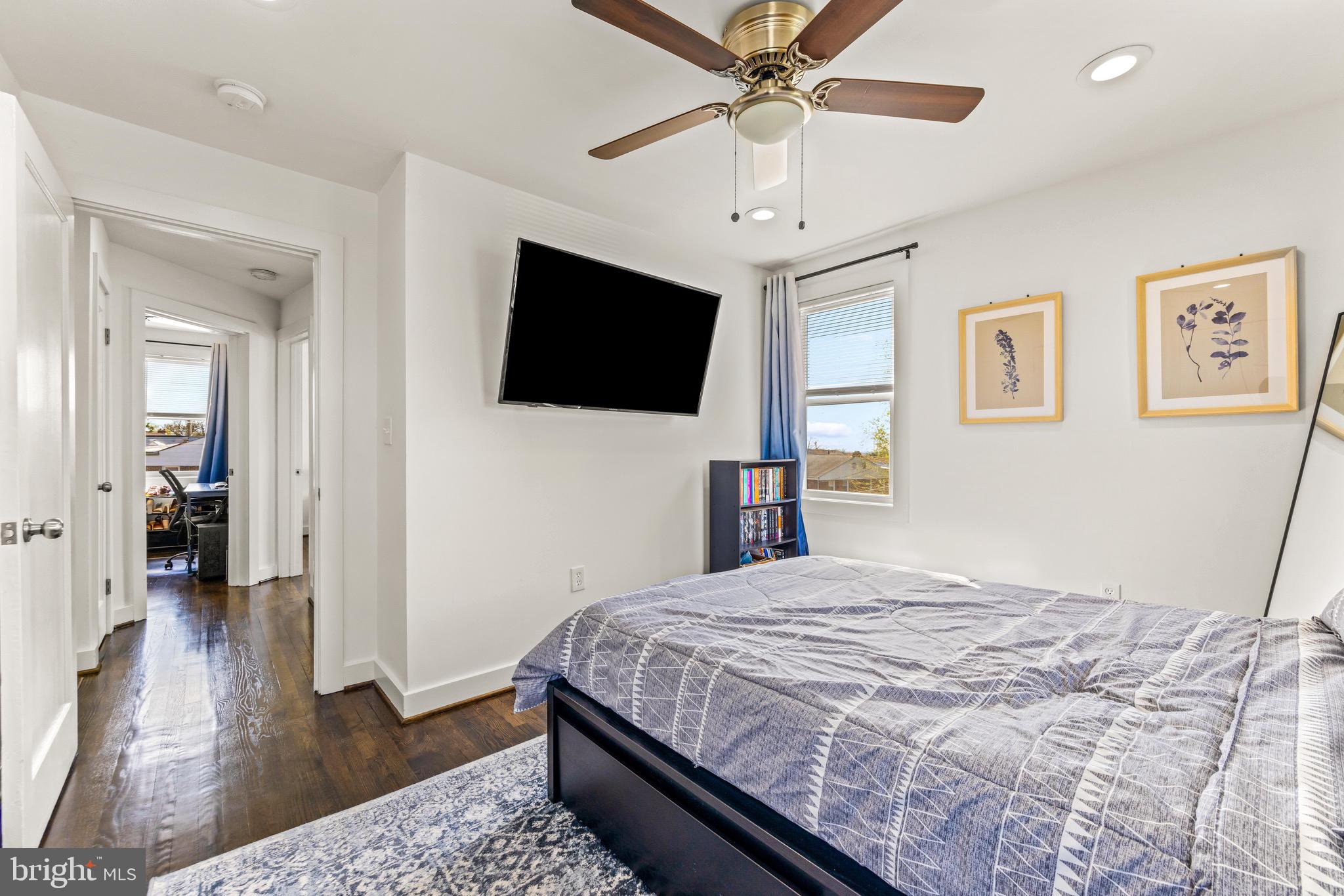 57 Upmanor Road Baltimore, MD 21229 - Photo 13 of 27 a bedroom with a large bed a flat tv screen and a chandelier