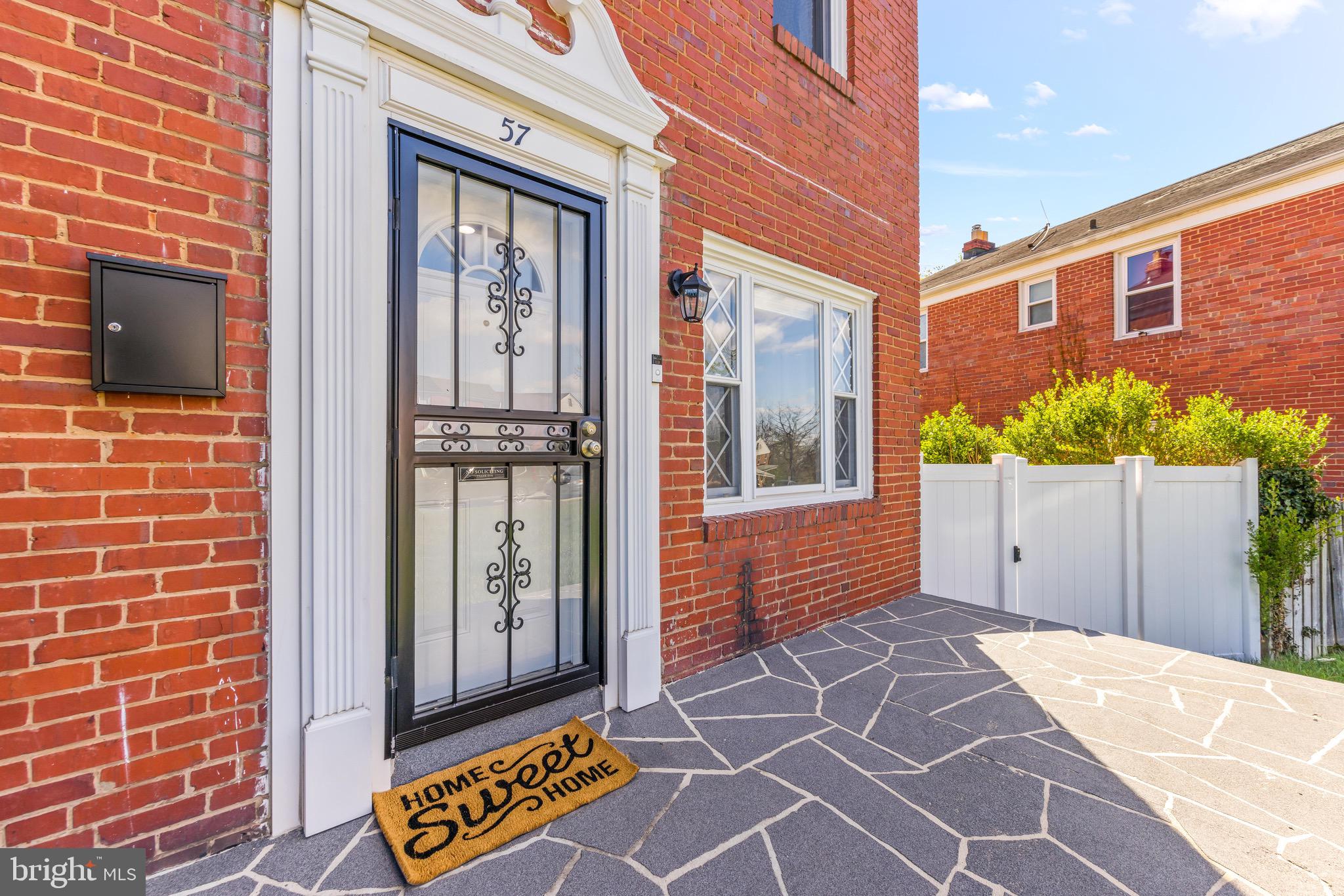 57 Upmanor Road Baltimore, MD 21229 - Photo 27 of 27 a view of a brick house with a door and a outdoor space