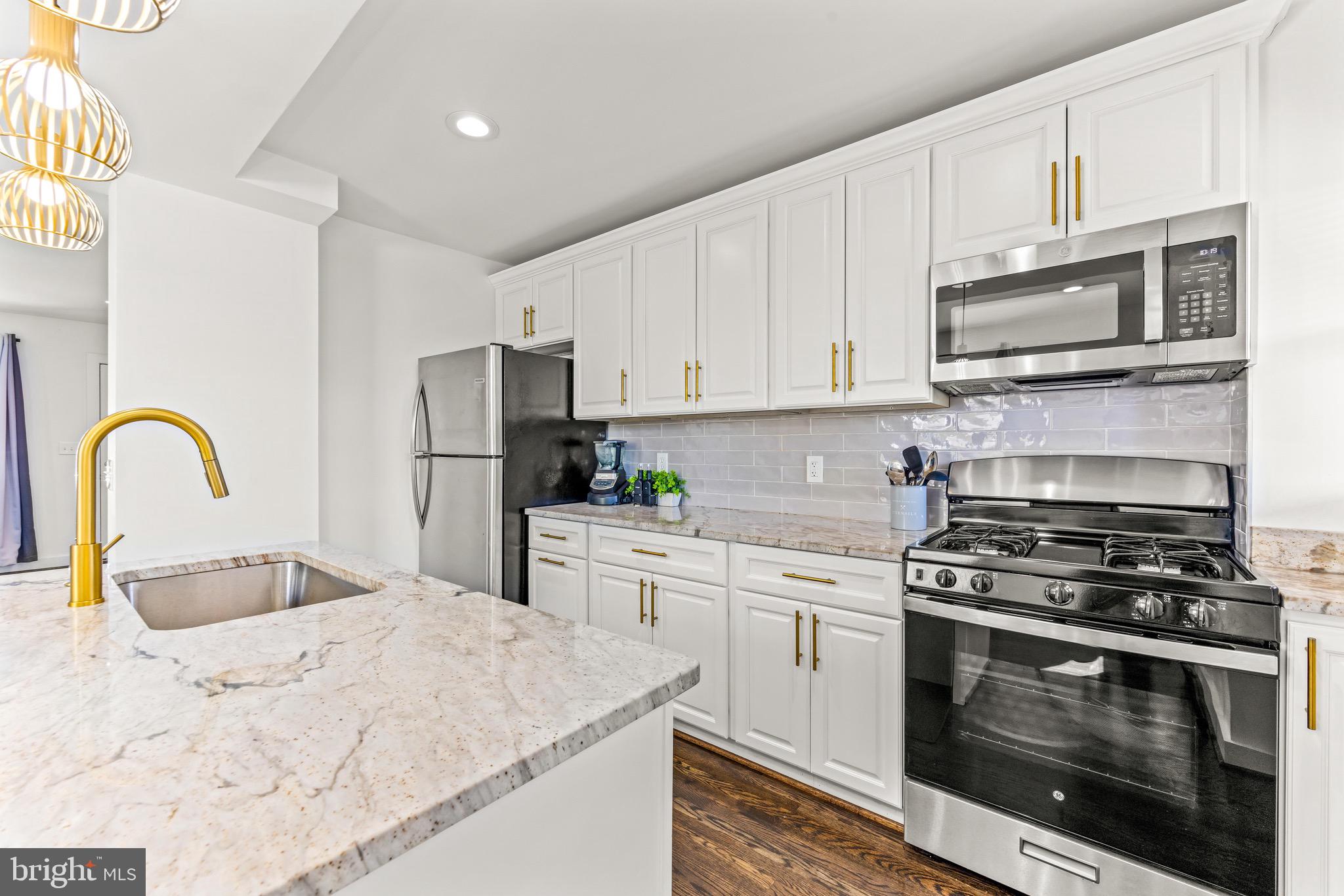 57 Upmanor Road Baltimore, MD 21229 - Photo 8 of 27 a kitchen with stainless steel appliances granite countertop a stove a sink and a microwave