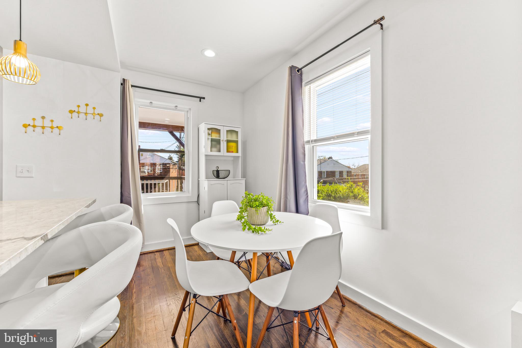 57 Upmanor Road Baltimore, MD 21229 - Photo 10 of 27 a view of a dining room with furniture a potted plant and wooden floor