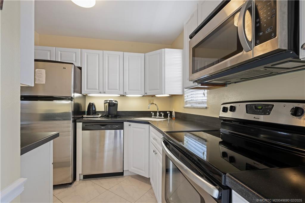 1961 Southwest Palm City Road, Unit F Stuart, FL 34994 - Photo 11 of 29 a kitchen with a stove microwave and sink