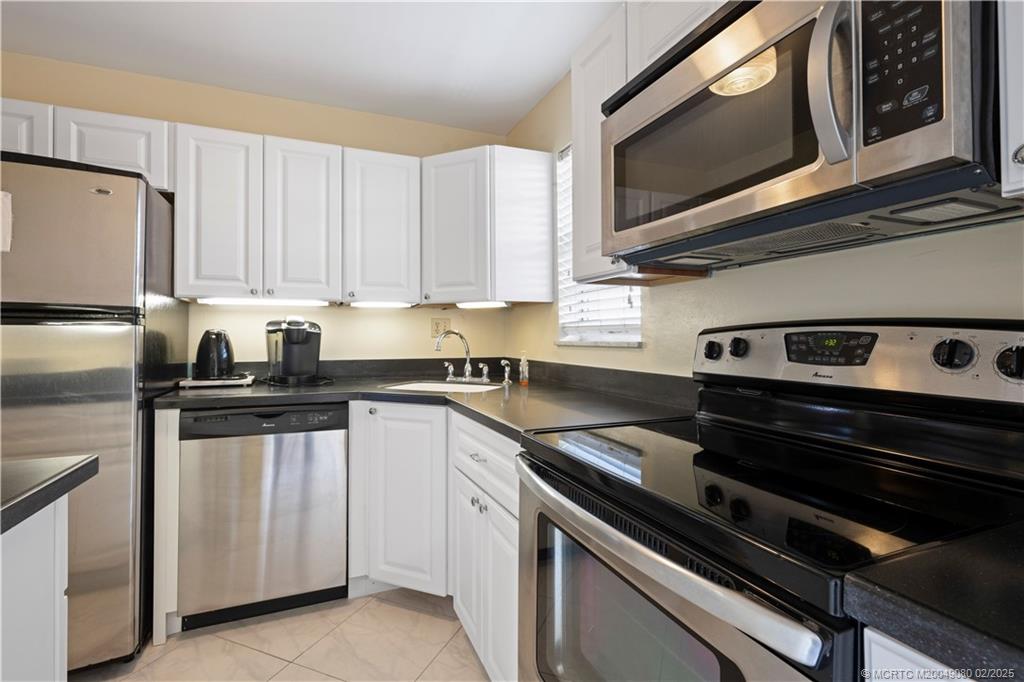 1961 Southwest Palm City Road, Unit F Stuart, FL 34994 - Photo 12 of 29 a kitchen with appliances a sink and cabinets