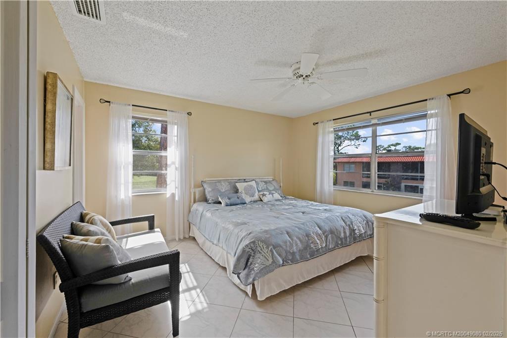 1961 Southwest Palm City Road, Unit F Stuart, FL 34994 - Photo 16 of 29 a bedroom with a bed and a flat screen tv