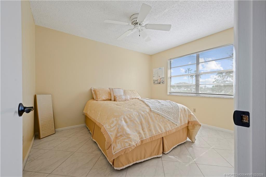 1961 Southwest Palm City Road, Unit F Stuart, FL 34994 - Photo 19 of 29 a spacious bedroom with a bed and a window