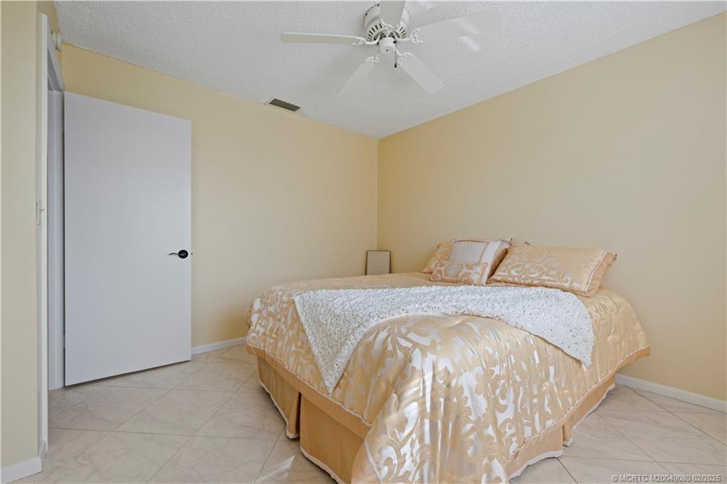 1961 Southwest Palm City Road, Unit F Stuart, FL 34994 - Photo 20 of 29 a bed sitting in a bedroom next to a bathroom