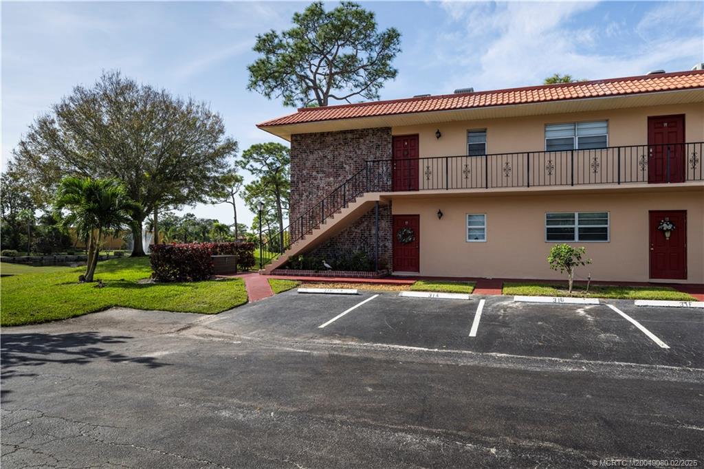 1961 Southwest Palm City Road, Unit F Stuart, FL 34994 - Photo 24 of 29 a front view of a house with a yard and garage