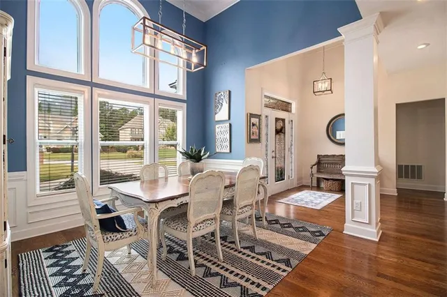 a dining room with wooden floor a glass table and chairs