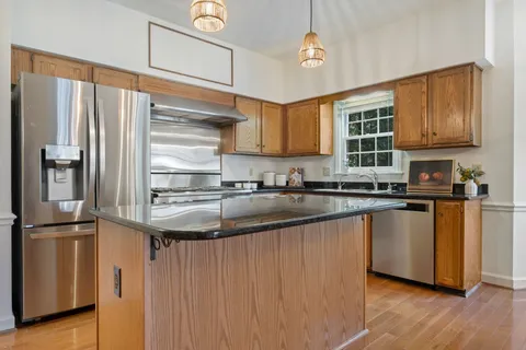 a kitchen with stainless steel appliances granite countertop a refrigerator a sink and a stove