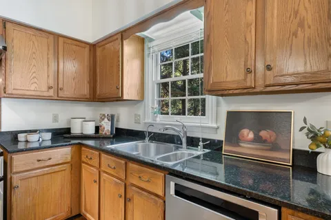 a kitchen with granite countertop a sink stainless steel appliances and cabinets