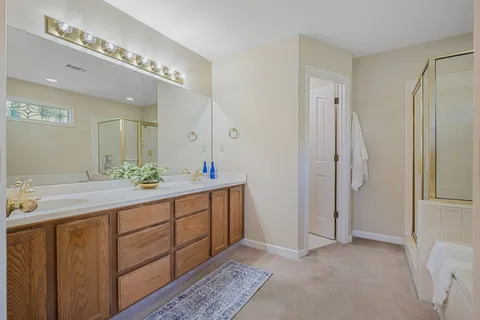 a spacious bathroom with a double vanity and a mirror