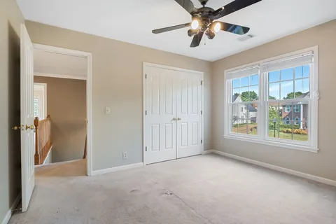 a view of an empty room with a window and a ceiling fan