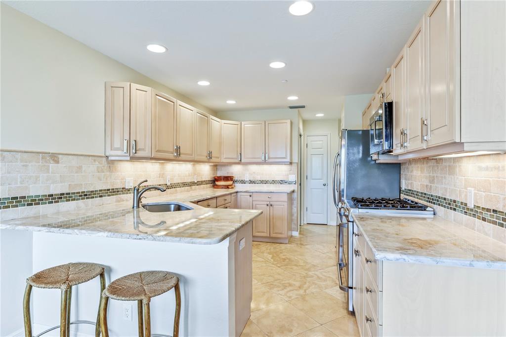 776 Beach View Drive Boca Grande, FL 33921 - Photo 9 of 36 a kitchen with stainless steel appliances granite countertop a sink stove and refrigerator