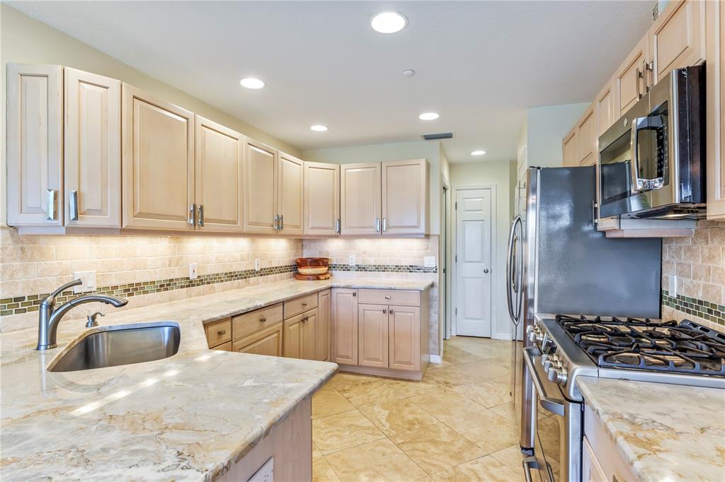776 Beach View Drive Boca Grande, FL 33921 - Photo 10 of 36 a kitchen with stainless steel appliances granite countertop a sink stove refrigerator and cabinets