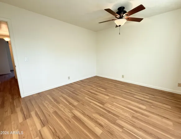 a view of a big room with wooden floor and a ceiling fan
