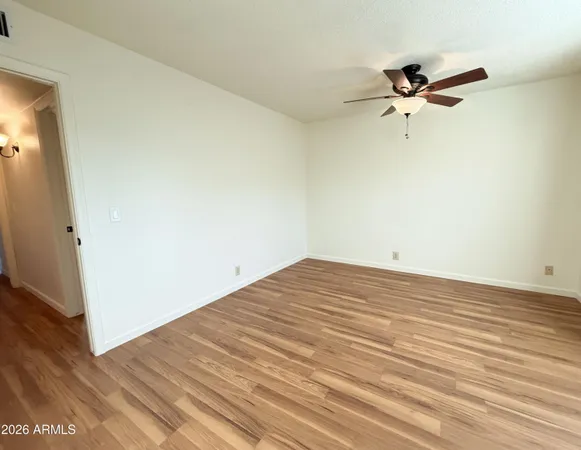 a view of a room with wooden floor and a ceiling fan