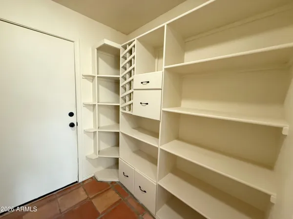 a view of walk in closet with empty racks