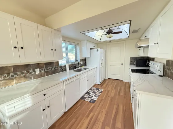 a large kitchen with kitchen island a sink stainless steel appliances and cabinets