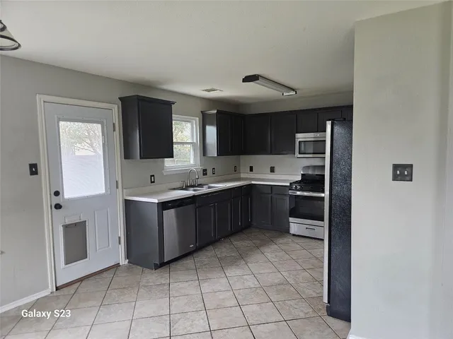 a kitchen with stainless steel appliances a sink and cabinets