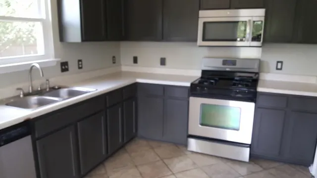 a kitchen with stainless steel appliances a sink a stove a microwave a sink and cabinets