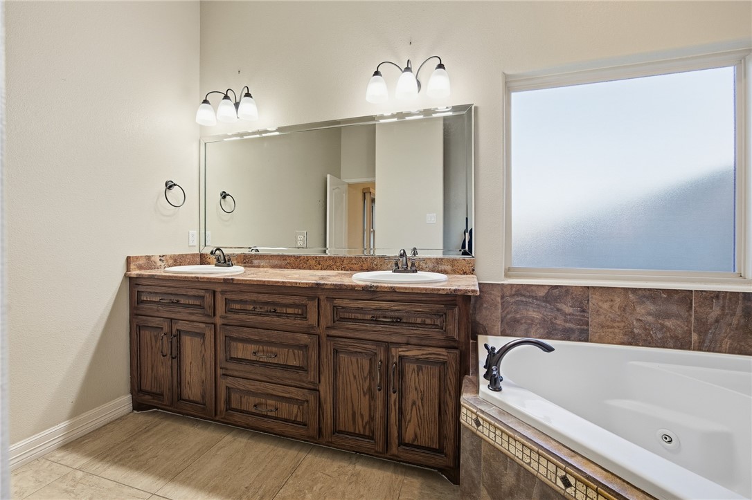 6934 Wooldridge Road, Unit R5 Corpus Christi, TX 78414 - Photo 13 of 32 a bathroom with a tub sink and mirror
