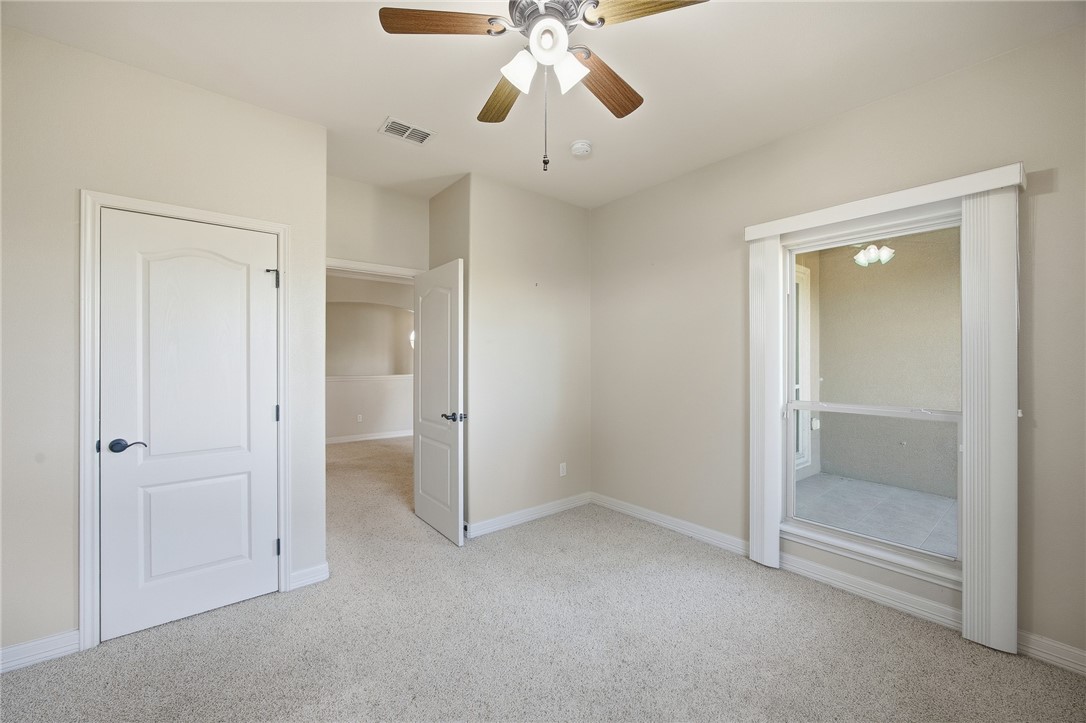 6934 Wooldridge Road, Unit R5 Corpus Christi, TX 78414 - Photo 21 of 32 an empty room with chandelier fan and closet area