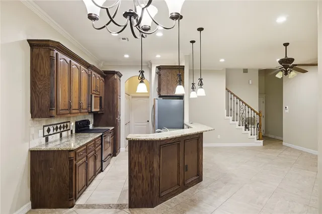 a kitchen with stainless steel appliances granite countertop a refrigerator and a stove top oven