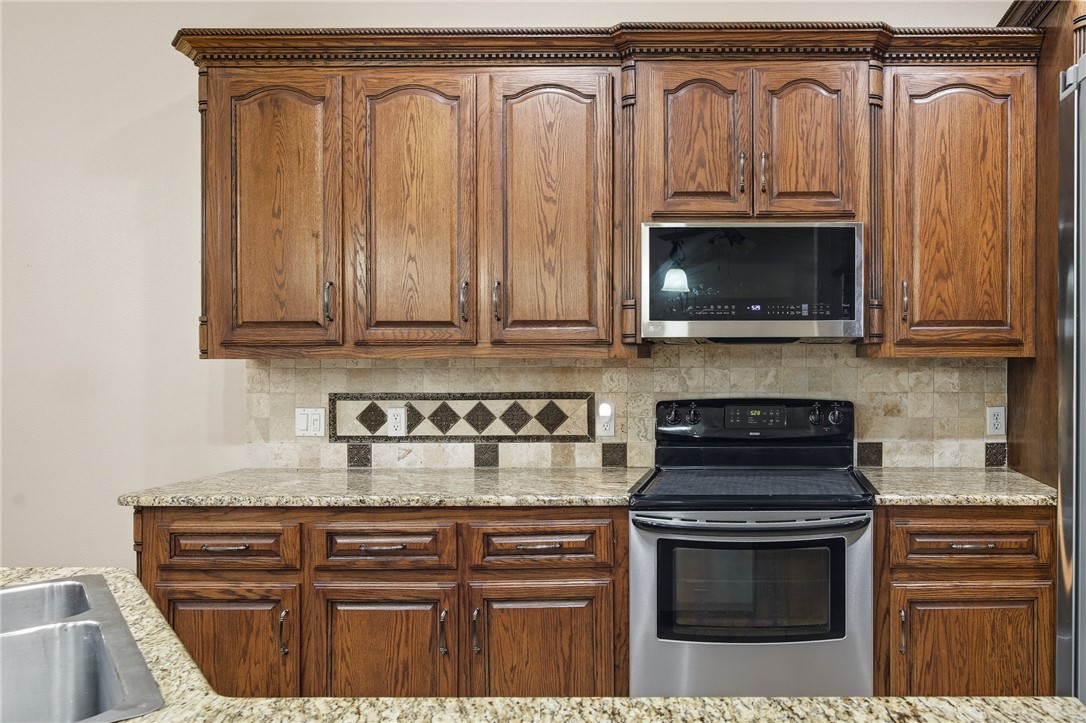 6934 Wooldridge Road, Unit R5 Corpus Christi, TX 78414 - Photo 7 of 32 a kitchen with granite countertop a stove and a microwave