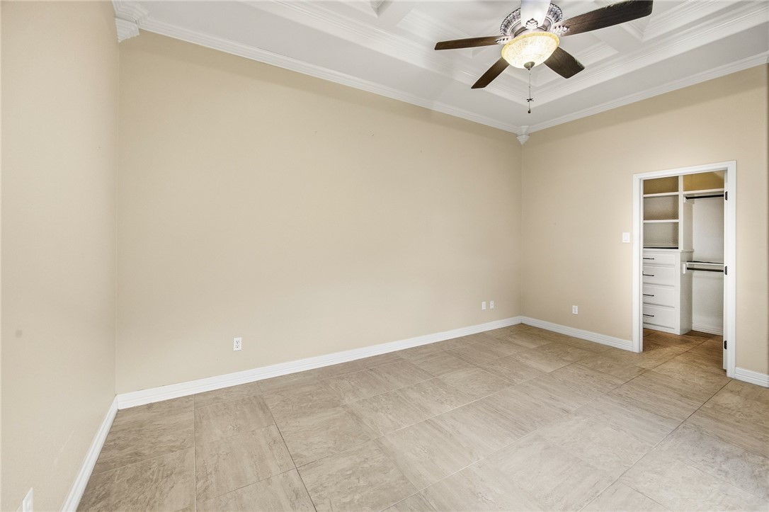 6934 Wooldridge Road, Unit R5 Corpus Christi, TX 78414 - Photo 8 of 32 an empty room with a ceiling fan and carpet