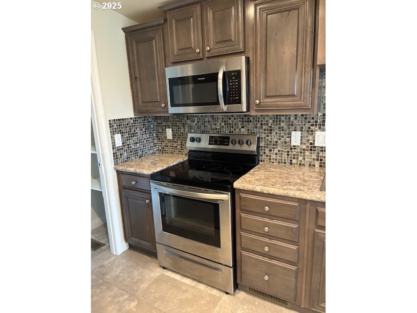 3108 Southwest River View Drive Pendleton, OR 97801 - Photo 19 of 37 a kitchen with stainless steel appliances granite countertop a stove microwave and sink
