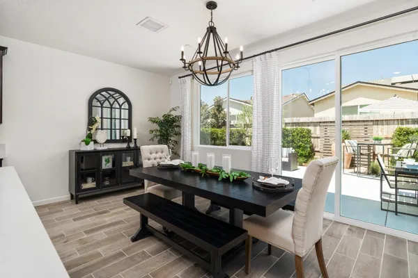 a dining room with furniture a chandelier and wooden floor