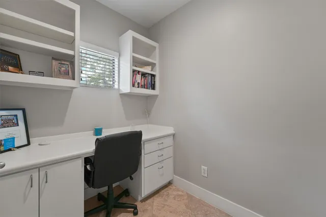 a view of a workspace with furniture and a window