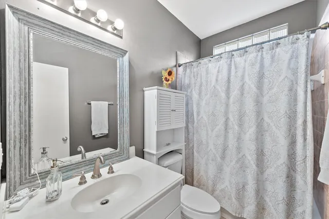 a bathroom with a sink a toilet and shower curtain