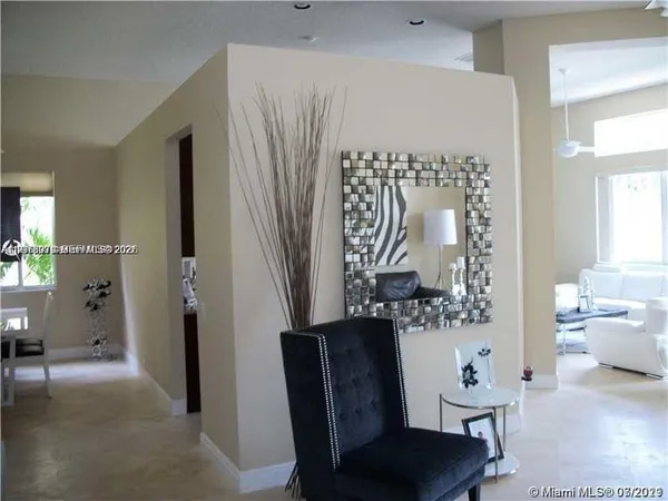 a view of a hallway with furniture and a chandelier