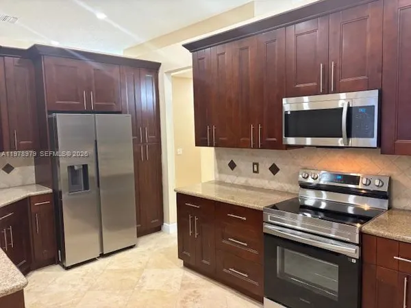 a kitchen with stainless steel appliances granite countertop a stove a refrigerator and a sink