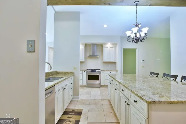 a dining room filled a chandelier and kitchen view