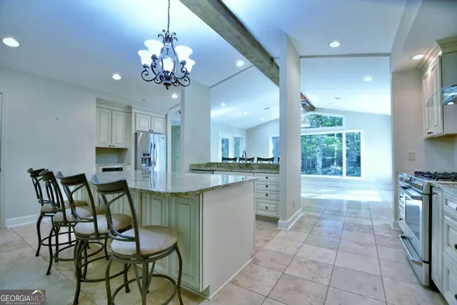 a view of an empty room with a window and chandelier