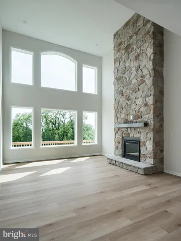 an empty room with windows and fireplace