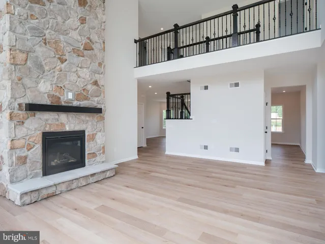 a view of a livingroom with wooden floor and a fireplace