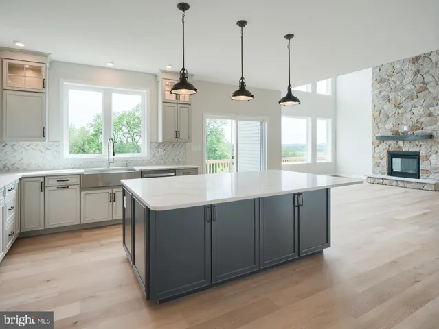 a kitchen with stainless steel appliances granite countertop a sink a stove a refrigerator and a window