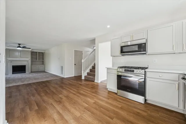 a kitchen with granite countertop a refrigerator and a stove top oven