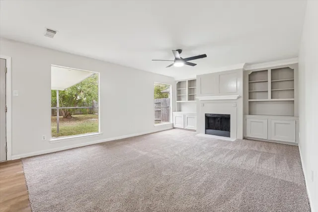 a view of empty room with a fireplace and window