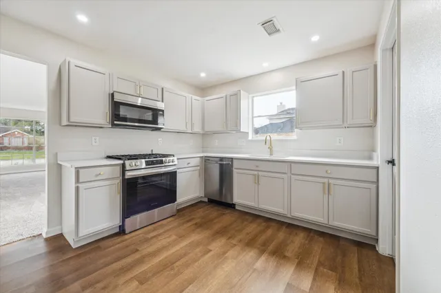 a kitchen with kitchen island white cabinets a sink and appliances