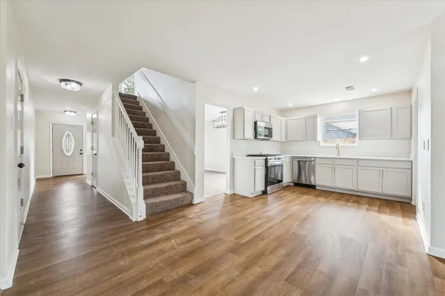 a view of a kitchen with wooden floor and electronic appliances