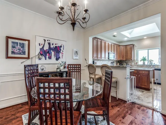 a view of a dining room with furniture a chandelier and wooden floor
