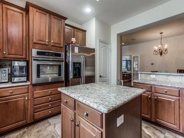 a kitchen with granite countertop wooden cabinets and stainless steel appliances