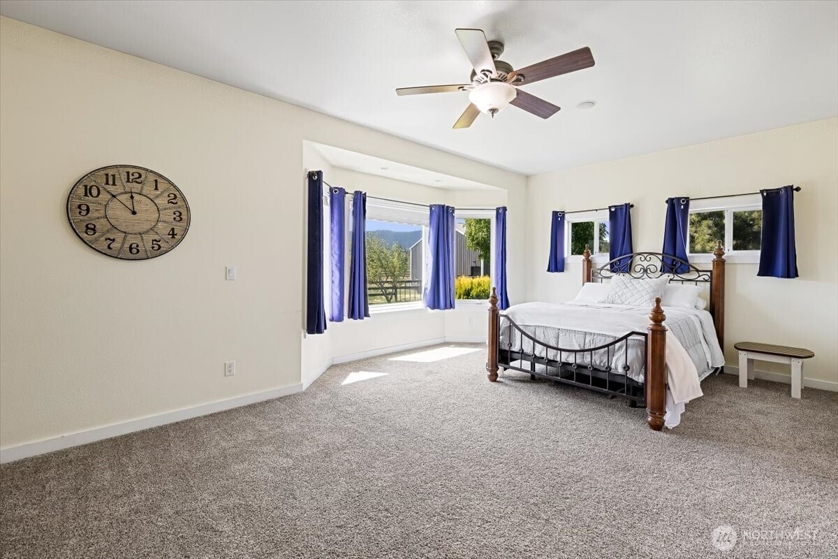 644 Masterson Road Cle Elum, WA 98922 - Photo 17 of 40 a spacious bedroom with a bed and a chandelier