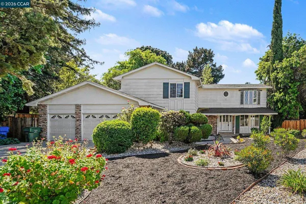 a front view of a house with a yard and plants