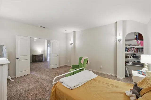 a bedroom with a bed and a view of kitchen