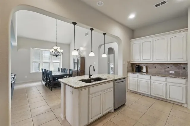 a kitchen with a sink and chairs