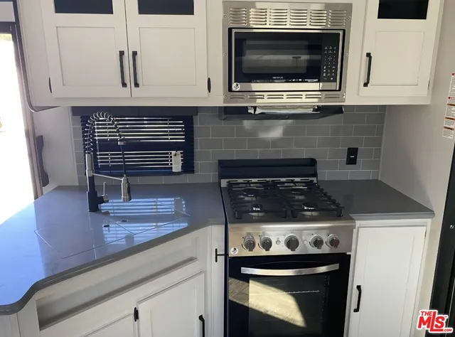 a kitchen with stove top oven and cabinets